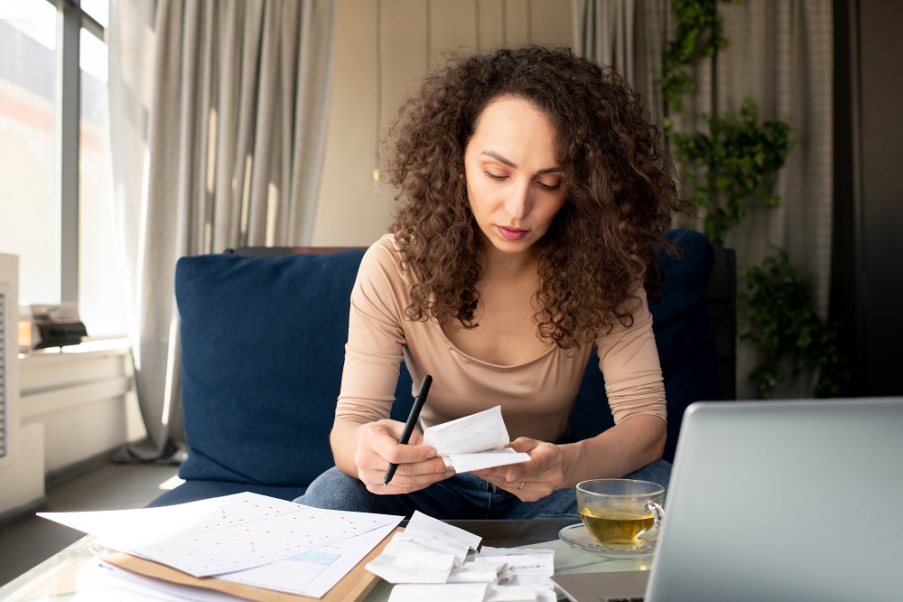 Young Serious Businesswoman With Long Wavy Hair Looking Through Payment Bills - Contabilidade na lapa - SP | Master Consultores